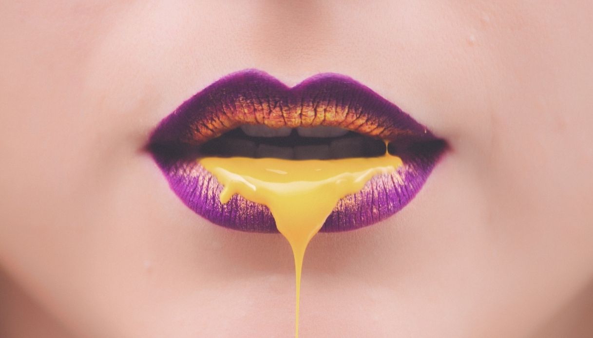 labbra viola e gialle con liquido che cola