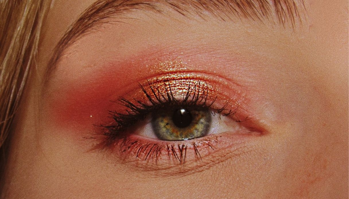 occhio verde con mascara e ombretto luminoso arancione