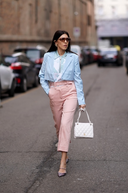 donna con giacca azzurra e pantaloni rosa