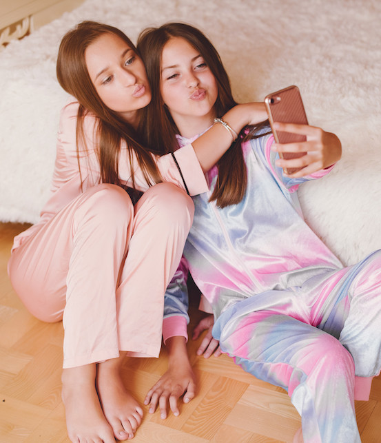 due ragazzine in pigiama che si scattano un selfie