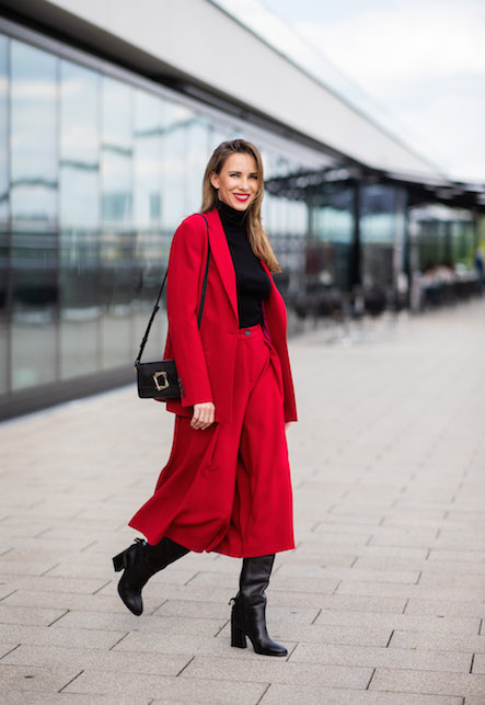 donna con gonna e giacca rossa, dolcevita, borsa e stivali neri