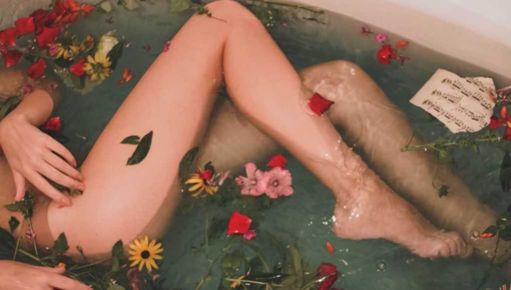gambe donna vasca da bagno e fiori