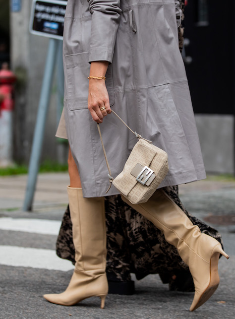donna con impermeabile grigio, borsa e stivali beige