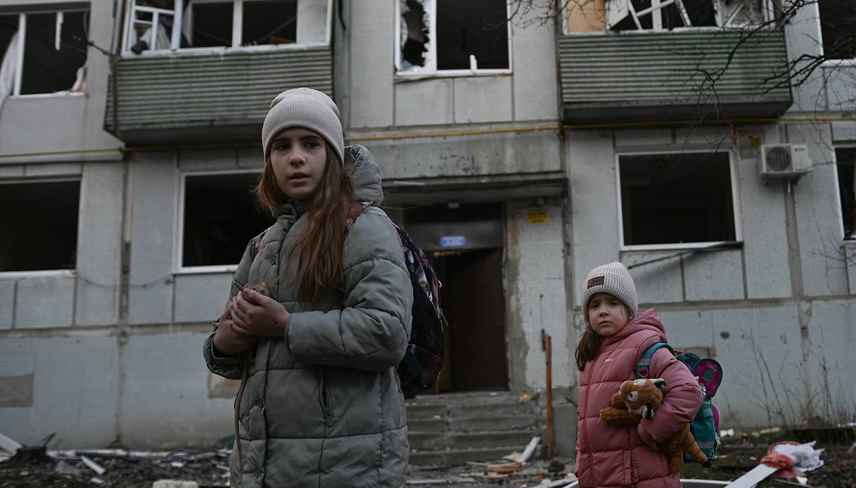 Ucraina, civili tra le case danneggiate dopo l'inizio dell'azione militare russa durante la notte.