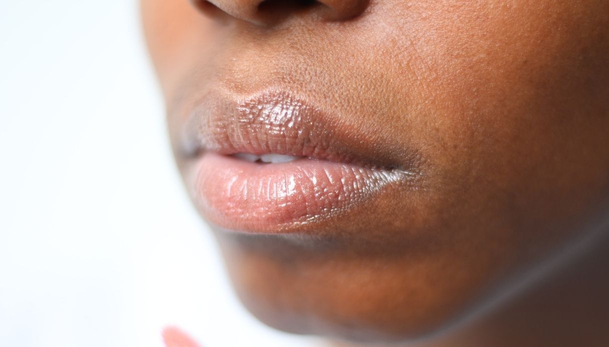 donna pelle nera con labbra carnose pigmentate e balsamo labbra