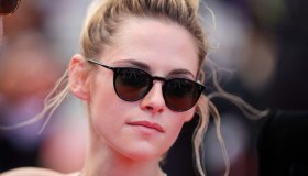 Cannes 2022, Kristen Stewart casual sul red carpet con mini top e occhiali da sole