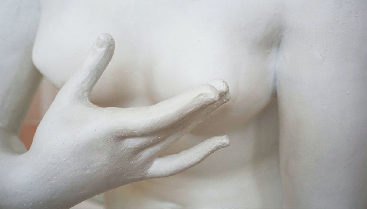 statua bianca con mano copre seno