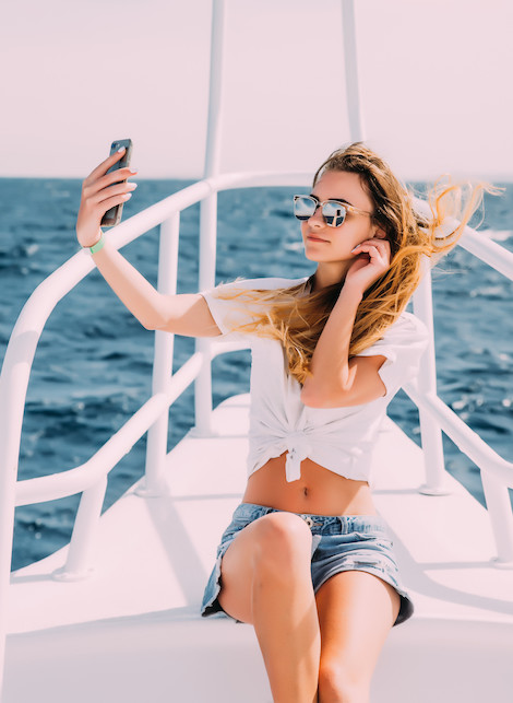 ragazza che si scatta selfie in barca a vela