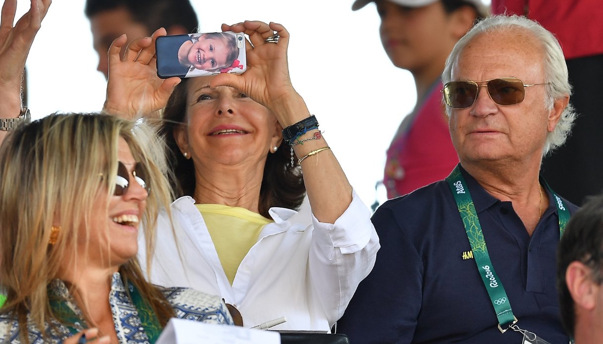 La Regina Silvia e il Re Carlo Gustavo di Svezia ai Giochi Olimpici di Rio 2016. La Regina scatta una foto con il suo cellulare che ha una foto di sua nipote, la principessa Estelle, nella cover