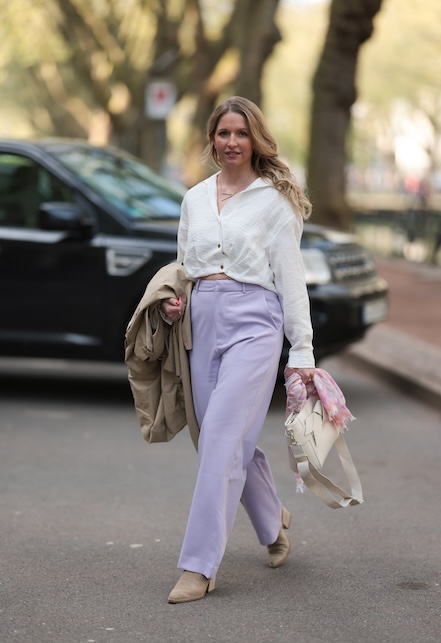 donna con pantaloni lilla e maglia bianca