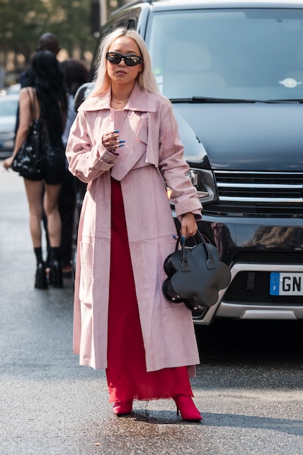 donna con abito rosso e trench rosa