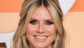 Heidi Klum, gonna cortissima e dettagli piumati: il look color cioccolato è super sensuale