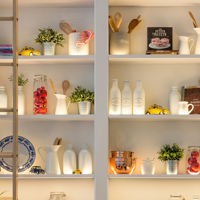 Mensole ben organizzate possono ospitare piccoli vasi di erbe, integrandosi perfettamente con l’arredo