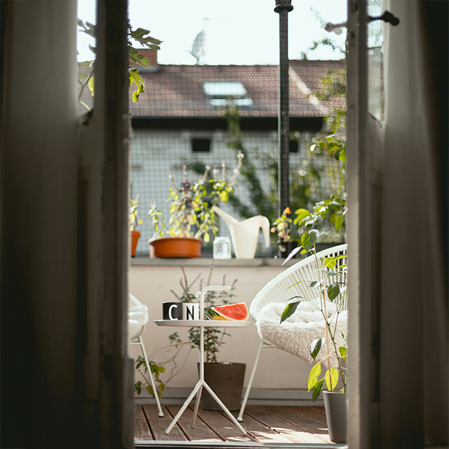 Anche un piccolo balcone può diventare un rifugio verde, con sedute leggere e vasi di erbe aromatiche