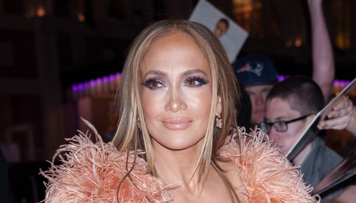 J.Lo, cambio di look mozzafiato, slip dress con boa e abito bianco da dea