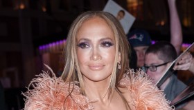 J.Lo, cambio di look mozzafiato, slip dress con boa e abito bianco da dea