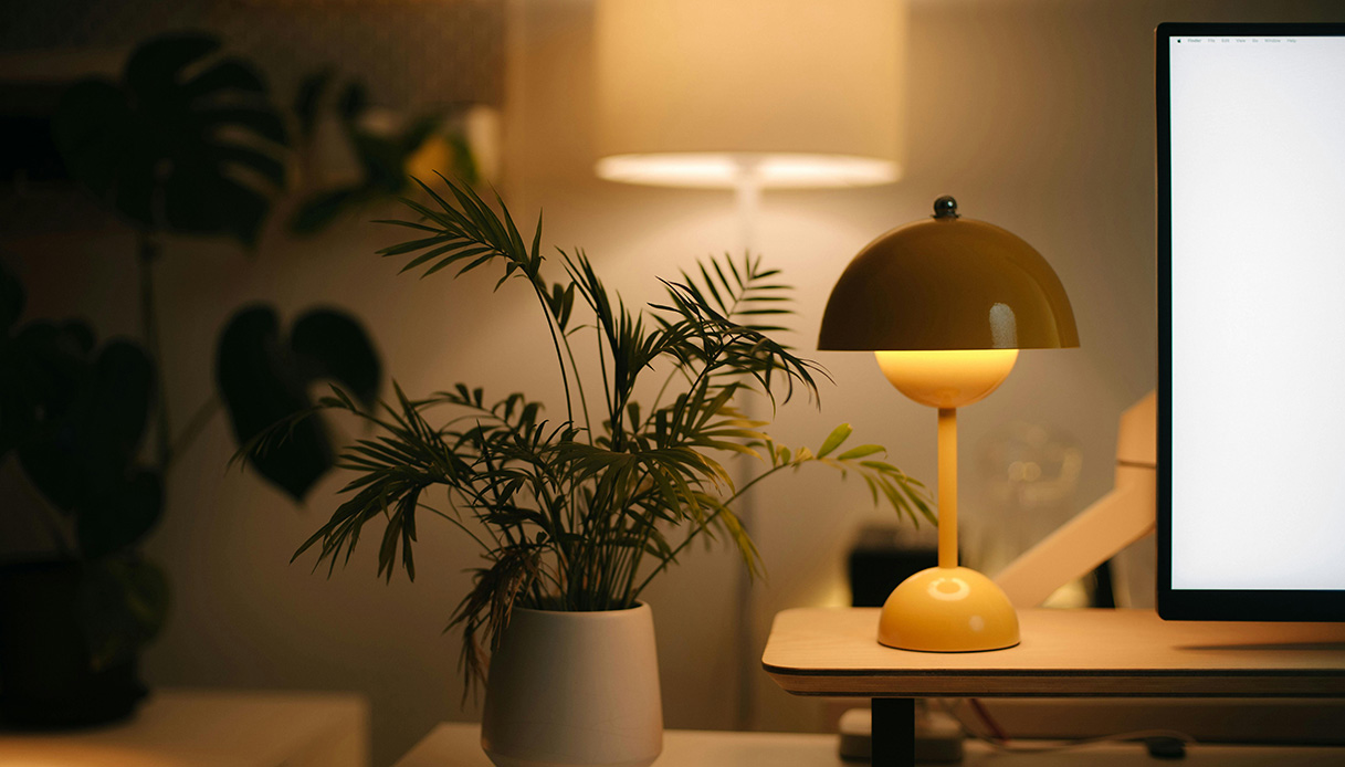 Una luce calda accanto al laptop favorisce il rilassamento serale, preparando il corpo per un riposo rigenerante