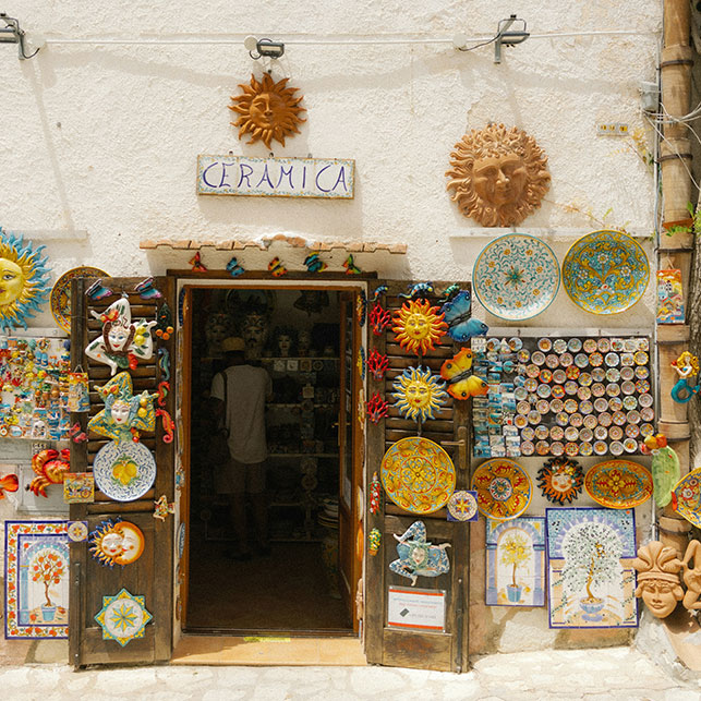 Ingresso di una bottega siciliana con ceramiche colorate esposte all’esterno