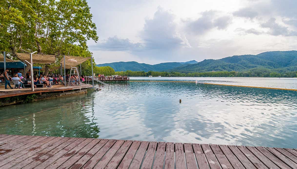 Pontili sul lago attrezzati per il bagno, con vista sulle montagne e caffè all’aperto