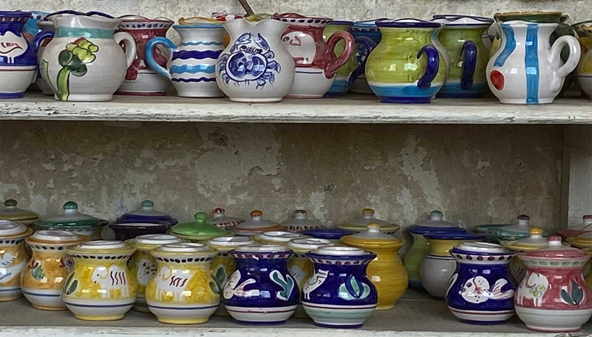 Brocche e barattoli decorati su mensola in muratura