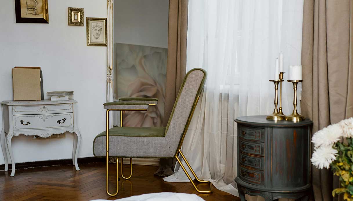 Arredi romantici con comò shabby chic e poltrona dalle linee morbide