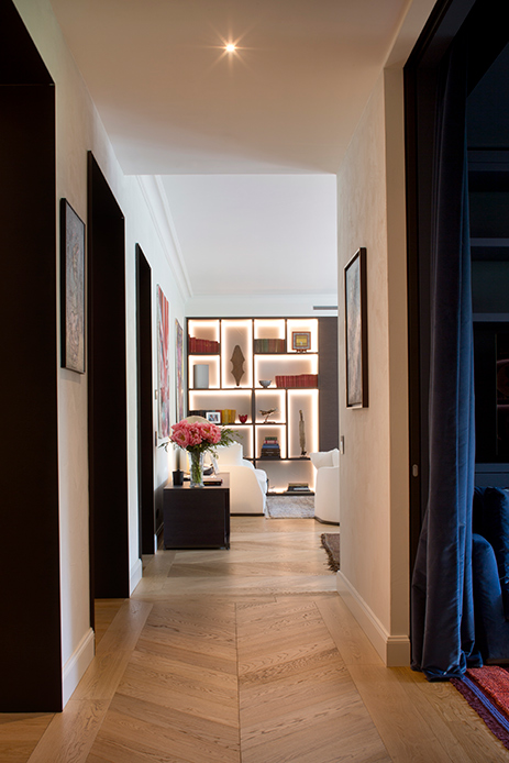 Corridoio con pavimento in legno e libreria retroilluminata in appartamento di lusso a Brera