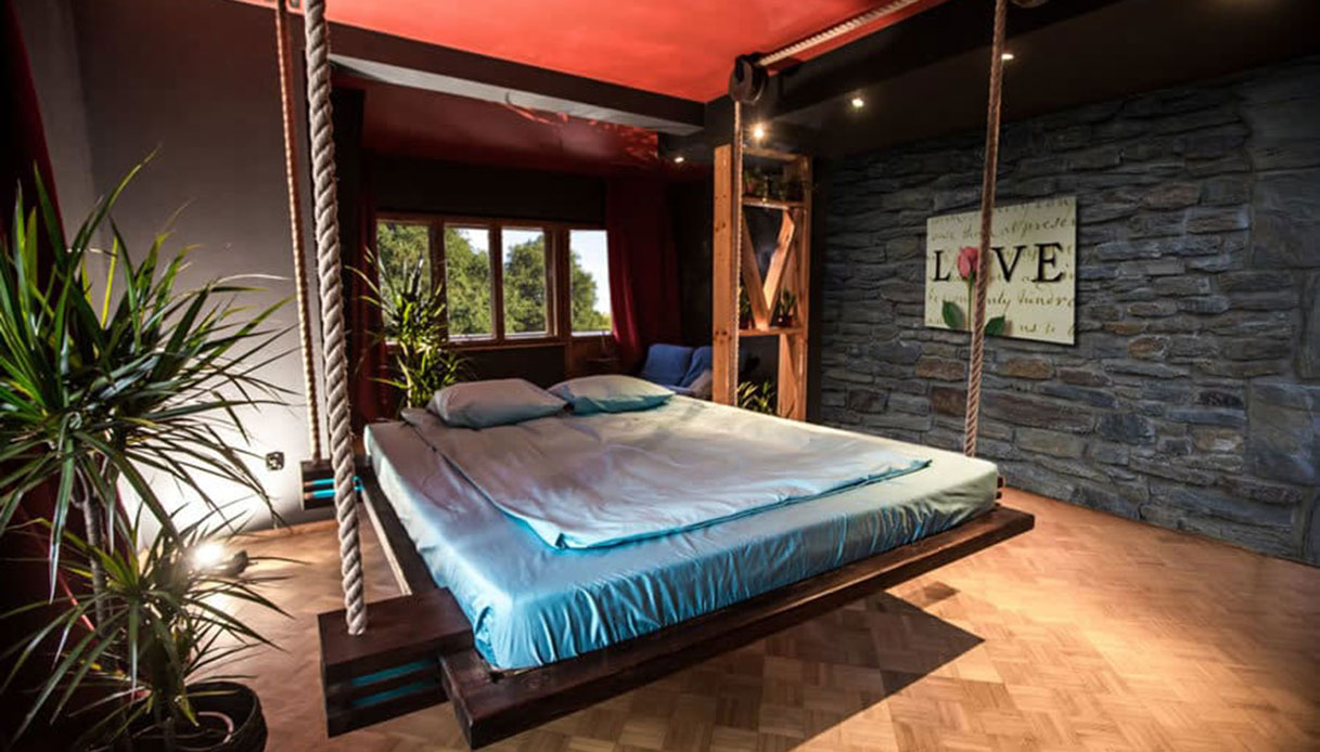 Letto sospeso con corde nautiche fissato al soffitto, stile rustico e accogliente