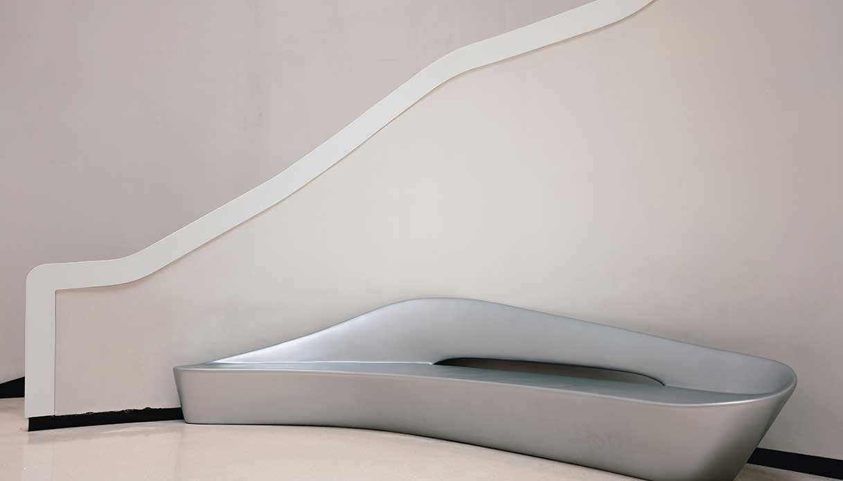 Panca di design dalle forme fluide in ambiente minimalista, ispirazione anni ’90