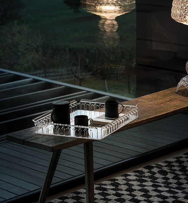 Vassoio PIAZZA di Kartell disegnato da Fabio Novembre, con dettagli architettonici, su tavolo in legno in un interno moderno