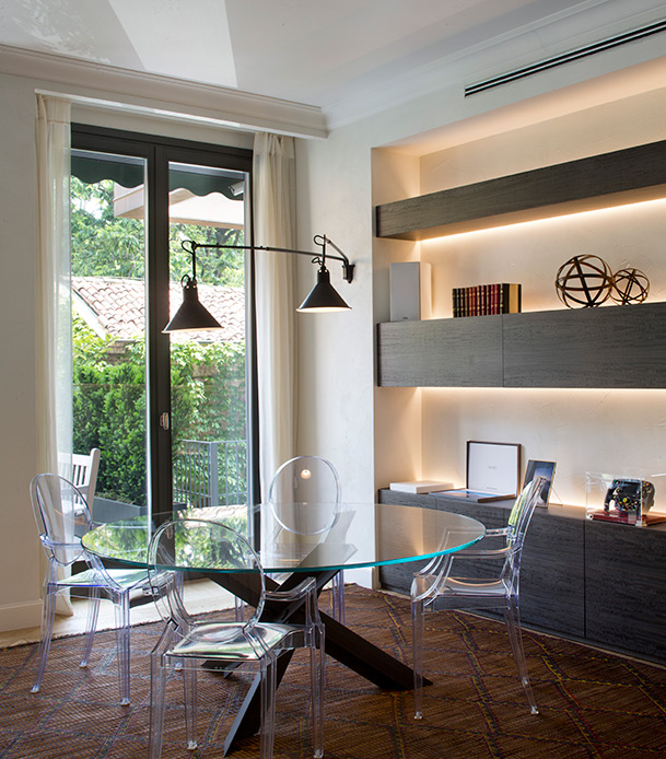 Sala da pranzo con tavolo Tulip di Eero Saarinen e sedie trasparenti in appartamento di lusso a Brera