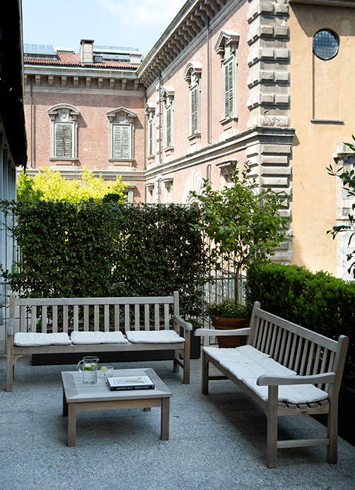 Terrazza in teak con panche e tavolino affacciata sull’Orto Botanico di Brera