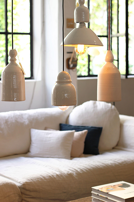 Interno scandinavo con lampade bianche sospese e divano in lino, arredamento in stile Hygge.