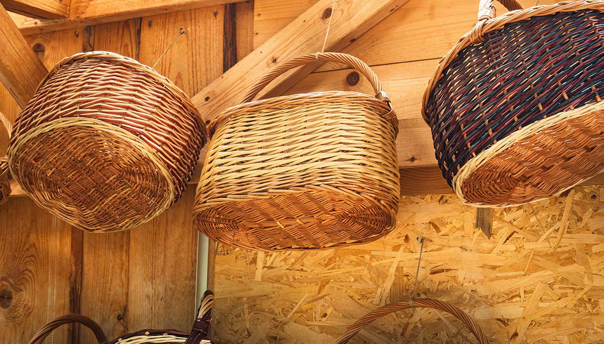 cesti in vimini intrecciati appesi a una parete in legno per decorazione rustica