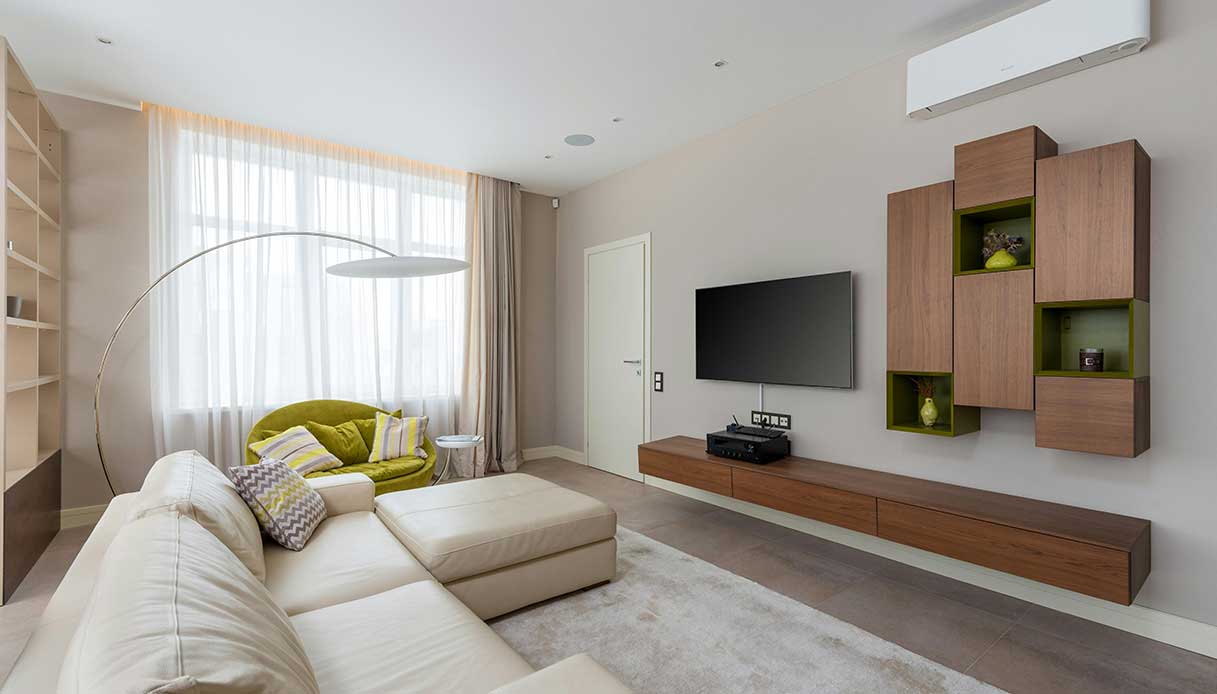 Soggiorno con divano beige e mobile in legno su pareti neutre