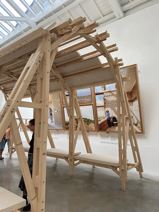 Padiglione Spagna Biennale Architettura 2025, struttura in legno con pannelli fotografici su materiali di recupero e artigianato