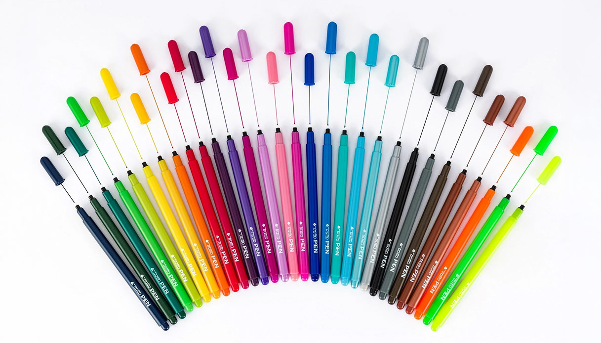 Pennarelli Tratto Pen Fila in vari colori disposti a ventaglio, con i cappucci sollevati collegati da sottili fili d&rsquo;inchiostro