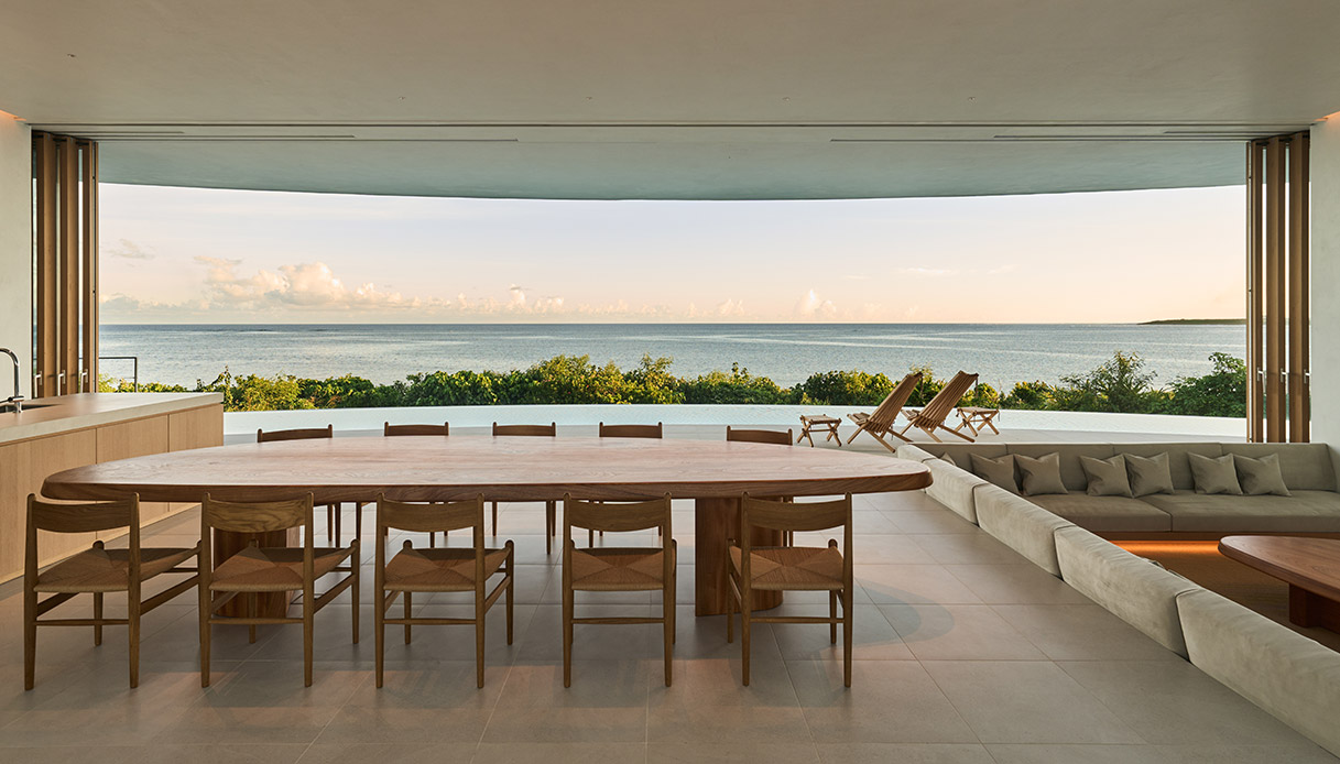 Living della villa Earth con grandi vetrate e vista mare