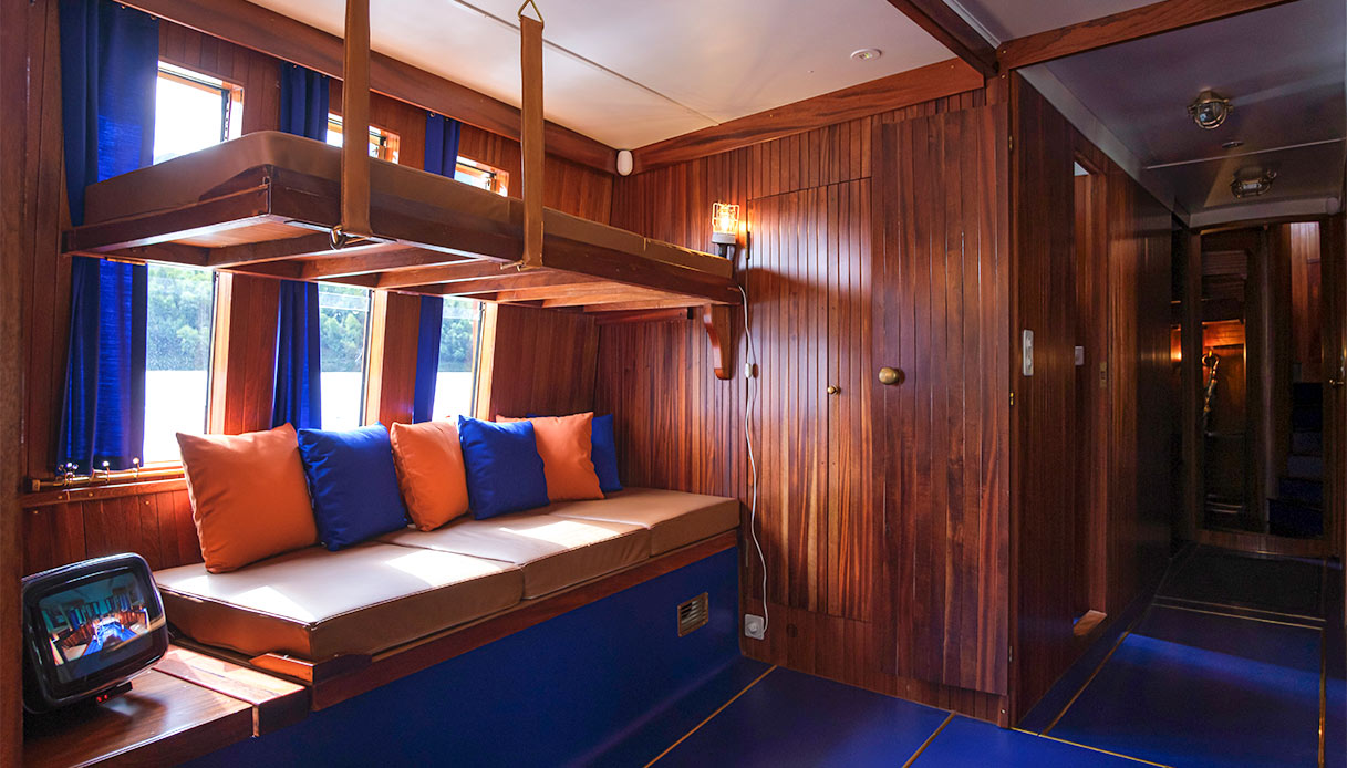 Cuccette ribaltabili e dettagli in legno all’interno della Velarca, casa-barca sul Lago di Como