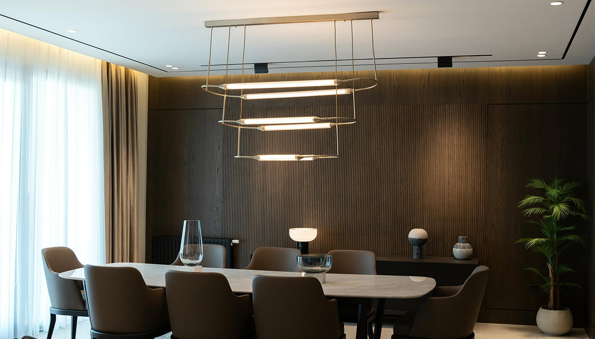 Sala da pranzo moderna con faretti LED e lampadario di design che creano luce diffusa e armoniosa