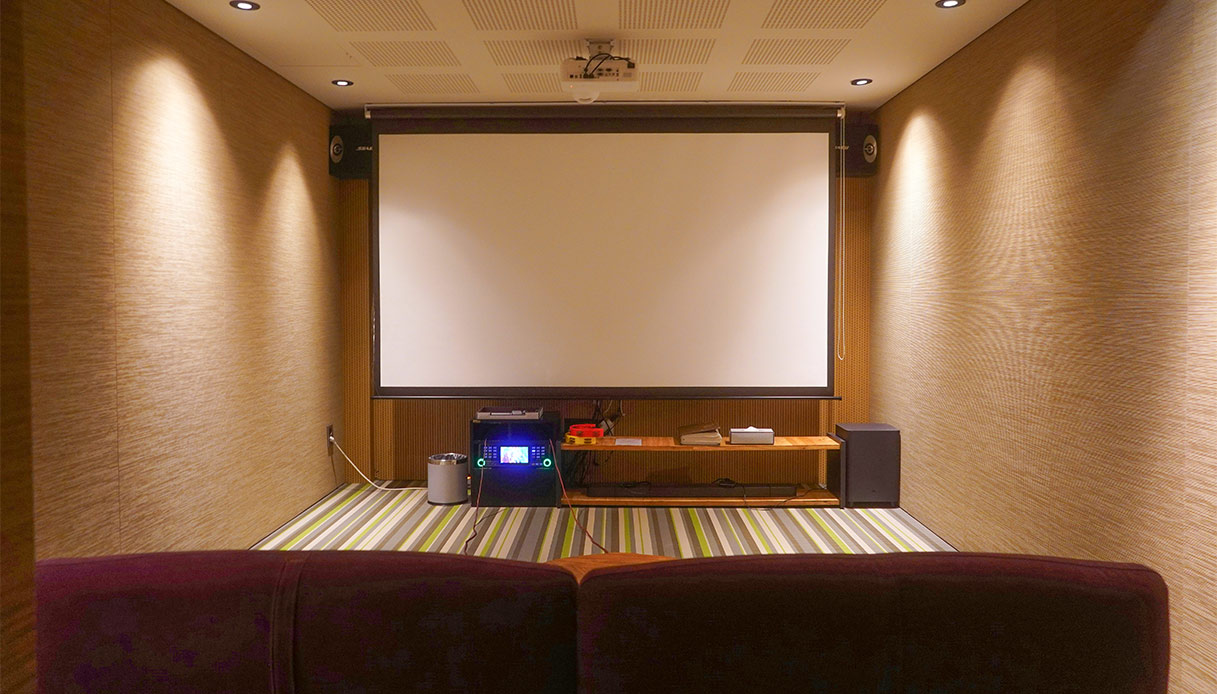 Home theater privato con pareti acustiche e grande schermo bianco illuminato