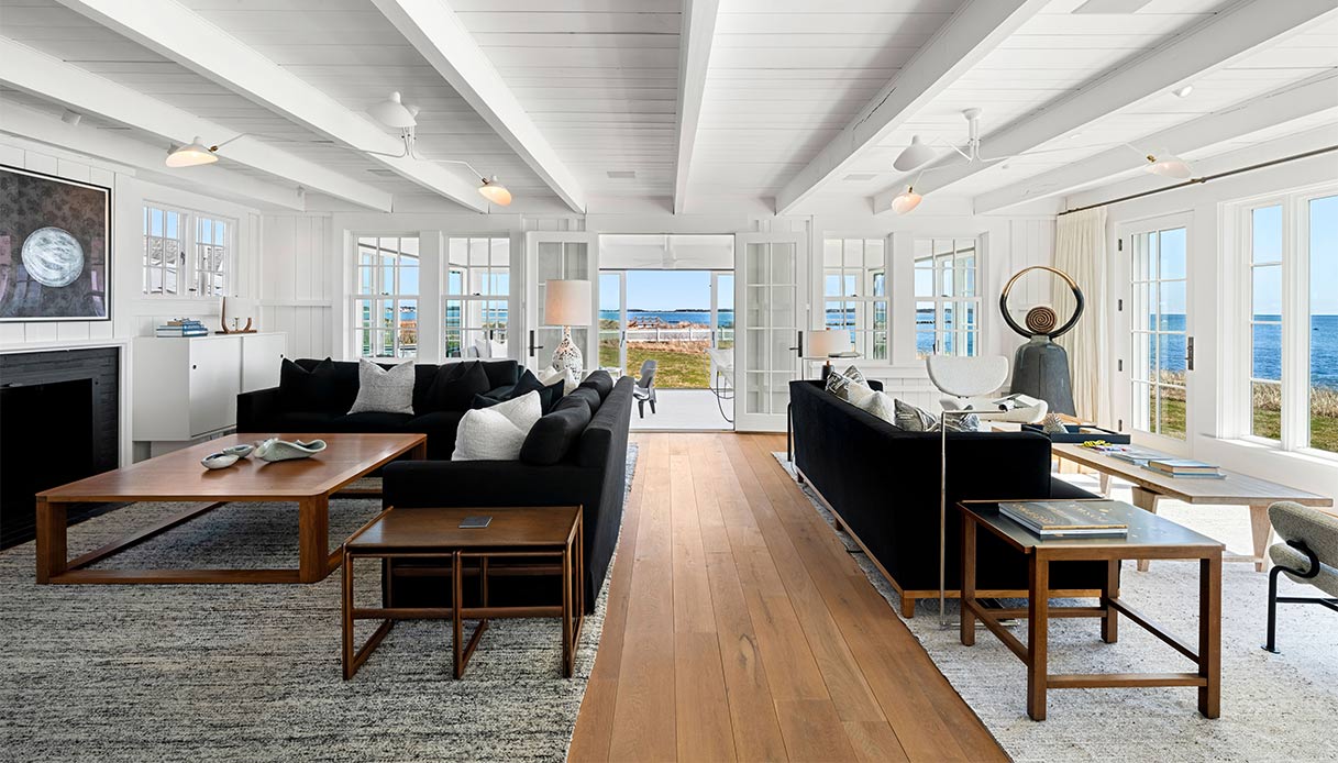 Soggiorno elegante con travi bianche a vista e ampie finestre vista mare nella villa di Taylor Swift