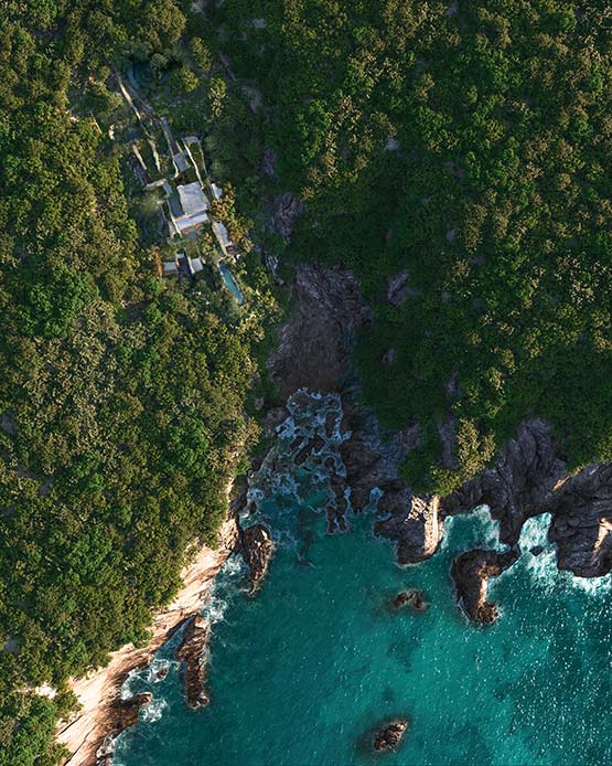 Veduta dall’alto della villa sull’isola di Yakushima, circondata dalla foresta e affacciata sul mare