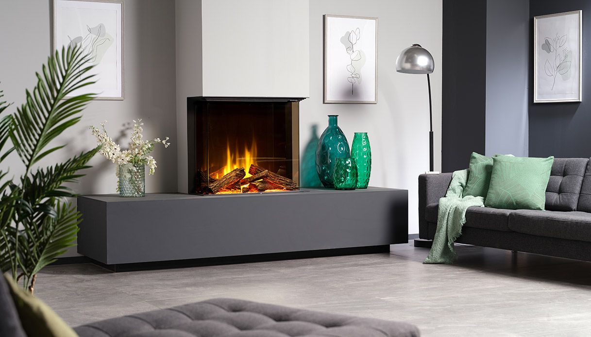 Camino elettrico ad angolo con fiamma realistica, integrato in una parete grigia e decorato con vasi in vetro verde in un salotto elegante.