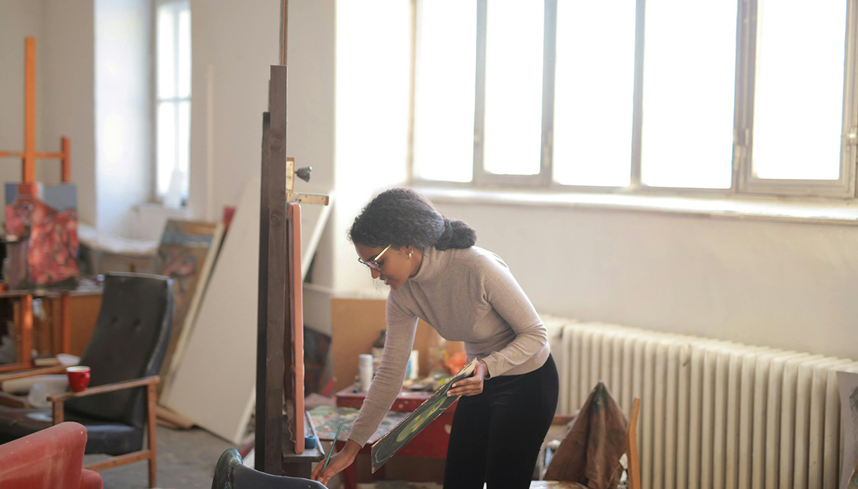 Persona che dipinge in uno studio d&rsquo;arte luminoso