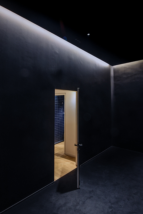 Ambiente minimal con pareti nero notturno e illuminazione d’accento
