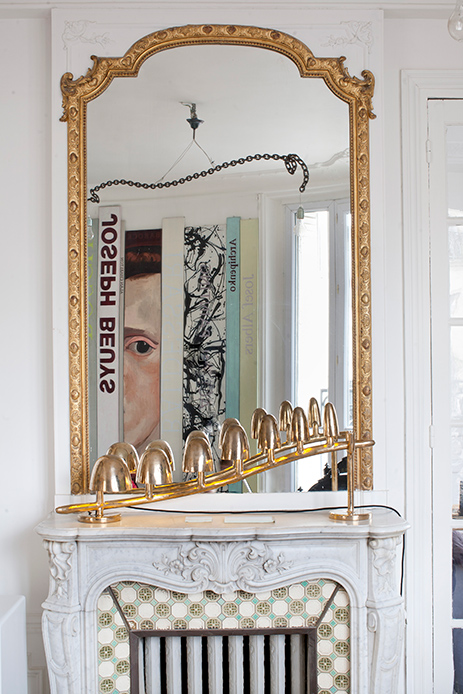 Camino in marmo con specchio dorato e lampada-scultura nella Maison Lombrail
