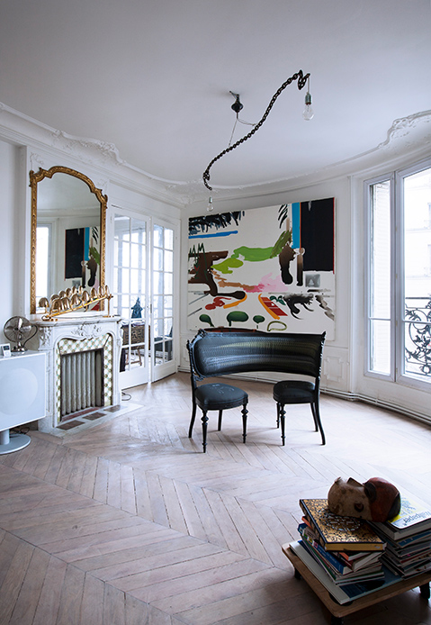 Salotto della Maison Lombrail con specchio dorato e dipinto astratto vicino al camino