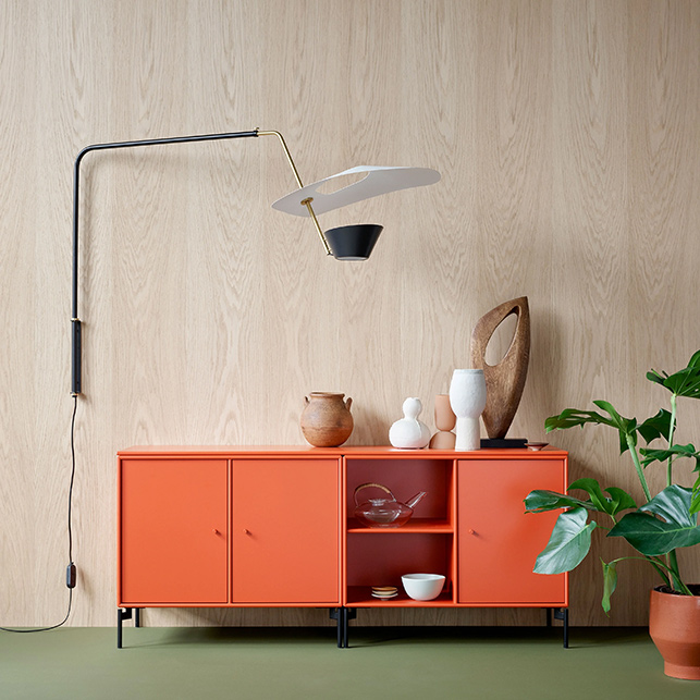 Madia modulare arancione con ripiani aperti e chiusi accanto a una lampada da parete
