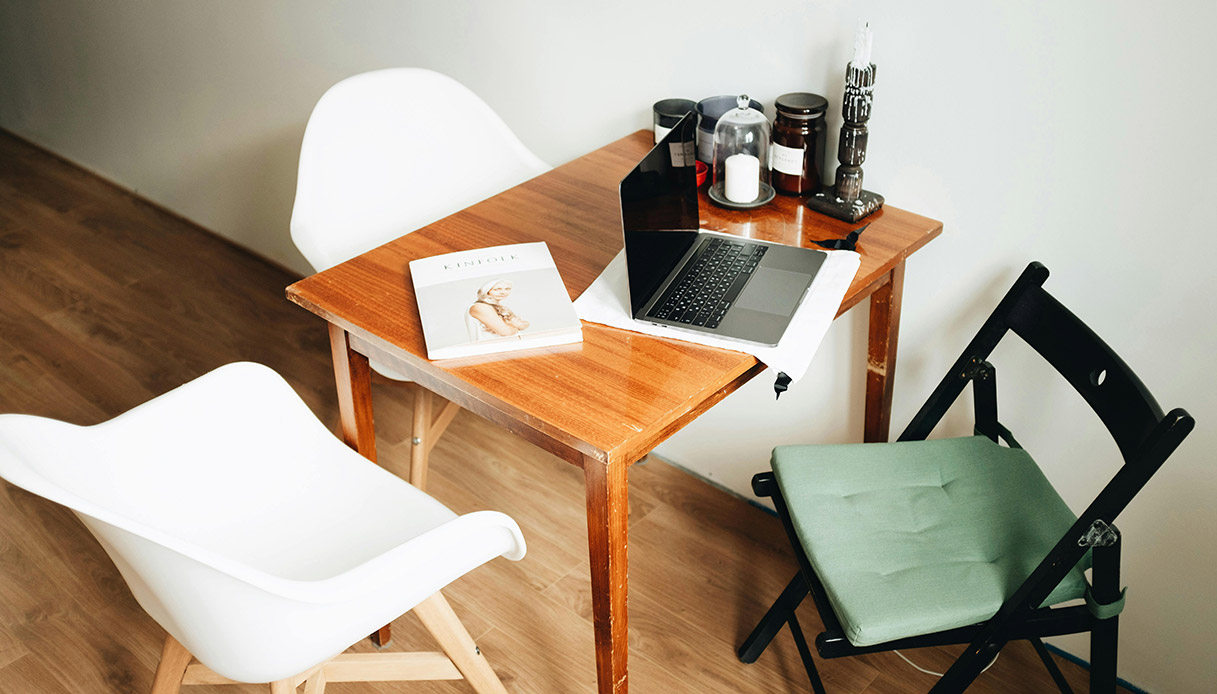 Scrivania con laptop e sedie in ambiente domestico