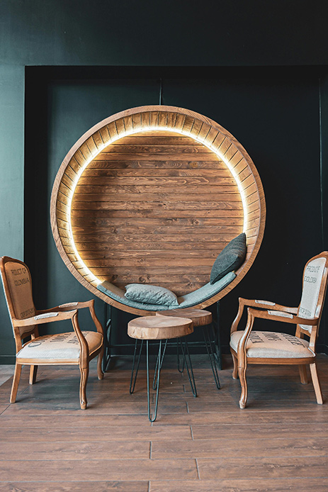 Seduta rotonda in legno con due poltroncine vicine